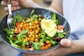 Clean eating, vegan healthy salad bowl closeup , woman holding salad bowl, plant based healthy diet with greens, chickpeas and