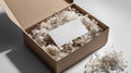 Open cardboard box mockup with white business card on shredded filler paper, modern flat lay Royalty Free Stock Photo