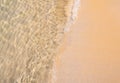 Clean empty beach background with space, movement of clear sea water and wave surf on sandy beach ocean. Royalty Free Stock Photo