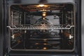 Clean and empty modern oven with an interior light and a central rack Royalty Free Stock Photo