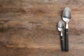 Clean empty table spoons on wooden background. Space for text