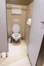 Clean empty toilet cubicle with open door in public restroom