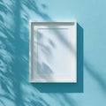 Empty White Picture Frame Mockup on Textured Blue Wall with Leaf Shadows Royalty Free Stock Photo