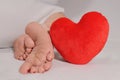 Clean female feet soles with red heart. Love your self, selfcare, footcare concept.