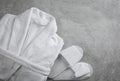 Clean folded bathrobe and slippers on stone background, flat lay Royalty Free Stock Photo