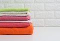 Clean folded terry towels on white shelf, bathroom interior