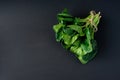 Clean food concept. Bunch of leaves of fresh organic spinach greens on a black background. Healthy detox spring-summer diet. Vegan Royalty Free Stock Photo