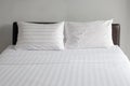 A clean, fresh bed with white linens and pillows in a hotel room. Rest and relaxation Royalty Free Stock Photo