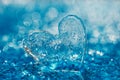 Clean glass heart on blue beach with water droplets Royalty Free Stock Photo