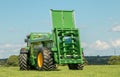 A green John Deere tractors pulling bunning muck spreaders