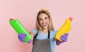 Clean home concept. Happy housewife in rubber gloves holds cleaning bottles in hands Royalty Free Stock Photo