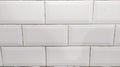 A clean, horizontal arrangement of white square tiles, creating a simple yet elegant pattern