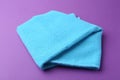 Clean light blue microfiber cloth on purple background, closeup Royalty Free Stock Photo