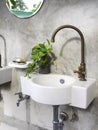 Clean loft style bathroom interior with white modern sink basin and brass faucet. Royalty Free Stock Photo