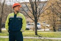 Clean male builder looks away. A man in special clothes and a helmet shows stands