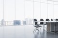 Clean meeting room interior with reflections on concrete flooring and panoramic window with city view and daylight. Commercial Royalty Free Stock Photo