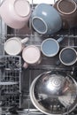 Clean metal cutlery and crockery, in the dishwasher, top view