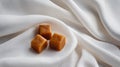 Clean minimal scene with a few caramels on white cloth background Royalty Free Stock Photo