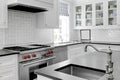 Luxury White Modern Kitchen Interior with White Cabinets with Gas Stove and Black Stone Counters