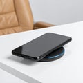Modern Smartphone Charging Wirelessly on a Desk Royalty Free Stock Photo