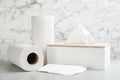 Clean napkins, box with tissues and rolls of paper towels on light table Royalty Free Stock Photo