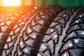 Clean new modern studded winter tires in row. Tires with spikes, close up Royalty Free Stock Photo