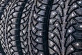 Clean new modern studded winter tires in row. Tires with spikes, close up Royalty Free Stock Photo
