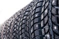 Clean new modern studded winter tires in row. Tires with spikes, close up, isolated Royalty Free Stock Photo