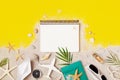 Clean notebook with accessories on yellow table top view. Planning summer holidays, travel and vacation background. Flat lay style
