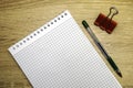 a clean open notepad for writing a fountain pen and a stationery clip on a wooden table Royalty Free Stock Photo