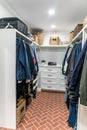 A clean and organized closet with some hanging clothes and shelves Royalty Free Stock Photo