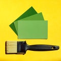 Clean paintbrush and three card samples of green colors