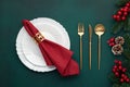 Clean plate, gold cutlery. Festive table setting with christmas decorations. Celebration xmas eve: flat arrangement. Red, golden