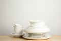 Clean plates, bowl and cups on table against white background. Space for text Royalty Free Stock Photo