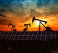 Clean power energy concept,Oil pump with solar panels and the sunset Royalty Free Stock Photo