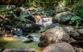 Clean and pure water streams in the creek flow through the rock boulders, Beraliya tropical rainforest. Peaceful natural scenery Royalty Free Stock Photo