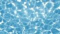 Clean quivering still water background. Pure blue water in the pool with light reflections.