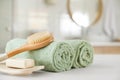 Clean rolled towels, massage brush and bar of soap in bathroom