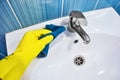 Clean shiny sink. Close-up gloved cleaner& x27;s hand. Wipes sink with rag. Royalty Free Stock Photo