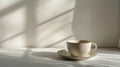 clean and simple arrangement featuring a plain ceramic plate and a cup, both white and empty, set on a neutral-toned table with a Royalty Free Stock Photo