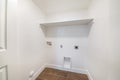 Clean small white empty laundry room with built in laundry connections Royalty Free Stock Photo