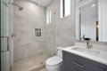 an interior view of a clean and spacious bathroom with grey cabinetry