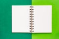 Clean spiral note book for notes and messages on green background. Minimal business flat lay