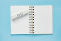 Clean spiral note book for notes and messages and june wooden calendar bar on blue background. Minimal business flat lay