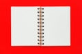 Clean spiral note book for notes and messages on red background. Minimal business flat lay