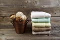 Clean stacked Towels and Bucket filled with Decorations on Weathered Wood