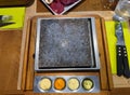 Clean stone grill on a restaurant table with decorative sauces, clean cutlery and steak around it is ready to be used by customers