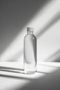 Clean transparent bottle stands in soft shadow with vertical framing in minimalistic setting Royalty Free Stock Photo