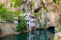 A clean underground river emerges from a cave near an mosque Royalty Free Stock Photo