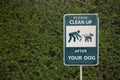 Clean Up After Your Dog sign against green grass in park Royalty Free Stock Photo